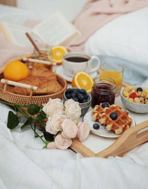 Café da manhã romântico com suco de laranja de waffles de café e flores rosas