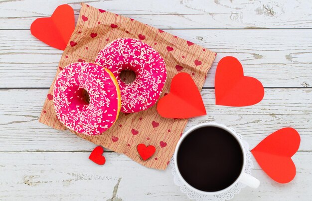 Café da manhã romântico do dia dos namorados. Presente, corações e donuts. Conceito de dia dos namorados. Copie o espaço.