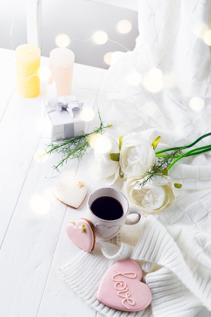 Café da manhã romântico na cama. Café, biscoitos, caixa de presente e flor na mesa de madeira. Conceito de dia dos namorados