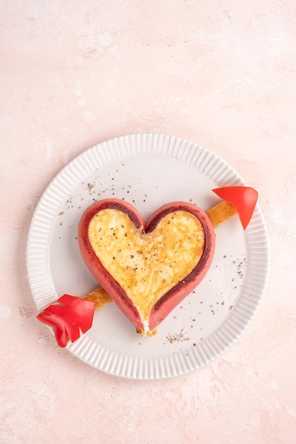 Café da manhã romântico ovos fritos em salsichas em forma de coração