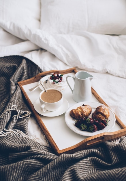 Café da manhã romântico tradicional na cama no quarto branco e bege
