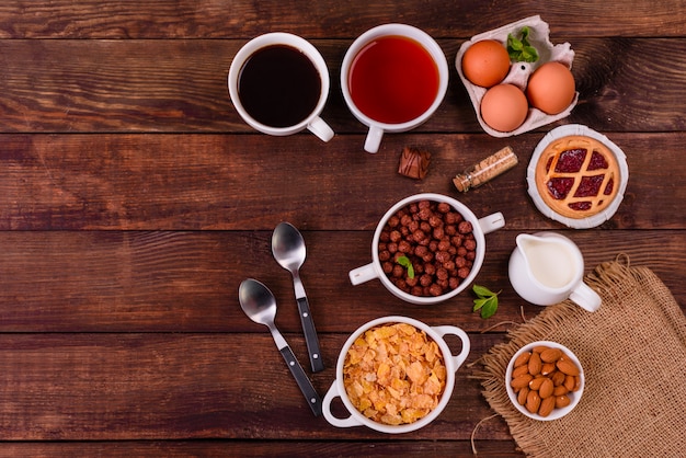 Café da manhã saboroso e útil com flocos, leite, nozes e frutas secas