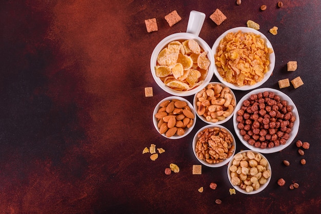 Café da manhã saboroso e útil com flocos, leite, nozes e frutas secas