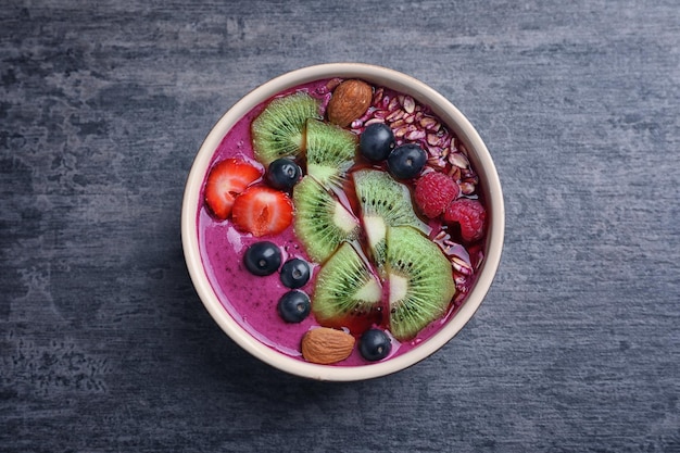 Café da manhã saudável com delicioso smoothie de açaí na tigela na mesa