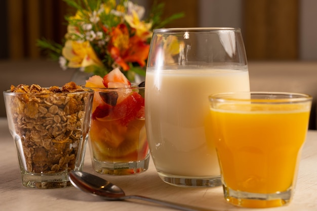 Café da manhã saudável com iogurte, granola, frutas e suco de laranja.