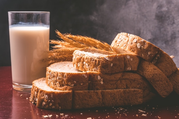 Café da manhã saudável com pão integral e leite inteiros na tabela.