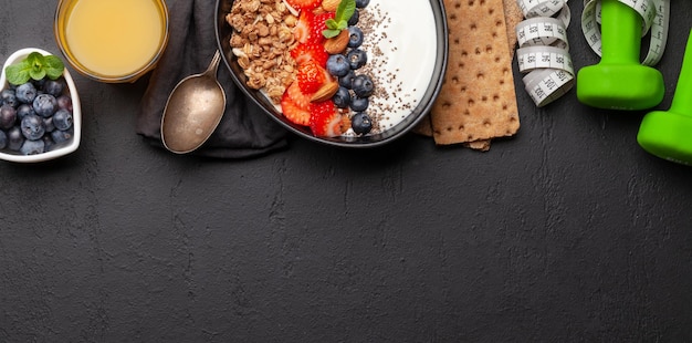 Café da manhã saudável com tigela de iogurte de granola e frutas frescas