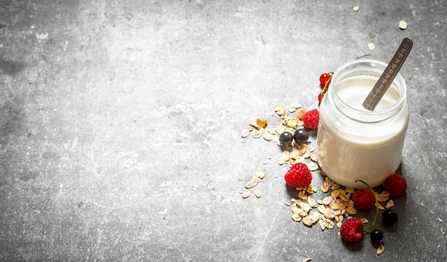 Café da manhã saudável . Creme de leite com cereais e frutas vermelhas. Na mesa de pedra.