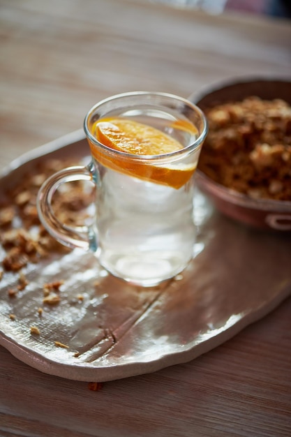 Café da manhã saudável de Champions Muesli um copo de água com uma fatia de laranjaCerâmica artesanal