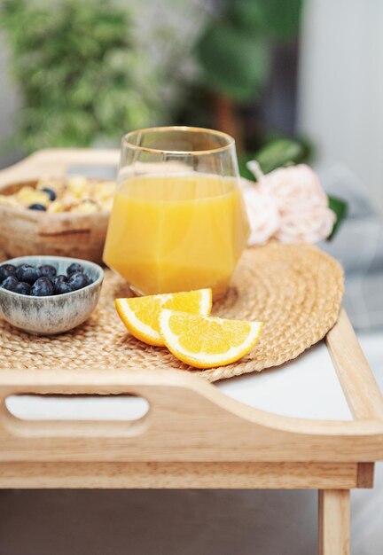Café da manhã saudável Frutas e tigela de suco de laranja com granola em uma bandeja Café da manhã na cama