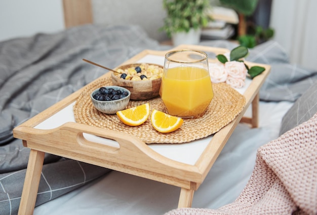 Café da manhã saudável Frutas e tigela de suco de laranja com granola em uma bandeja Café da manhã na cama