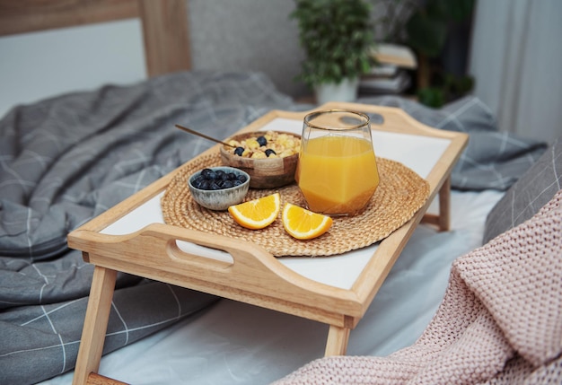 Café da manhã saudável Frutas e tigela de suco de laranja com granola em uma bandeja Café da manhã na cama