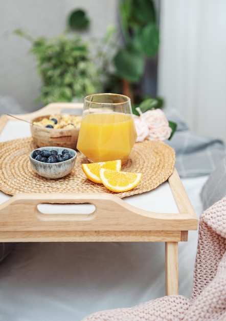 Café da manhã saudável Frutas e tigela de suco de laranja com granola em uma bandeja Café da manhã na cama