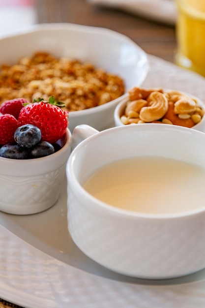 Café da manhã saudável. granola fresca, muesli com iogurte e frutas no fundo de mármore.