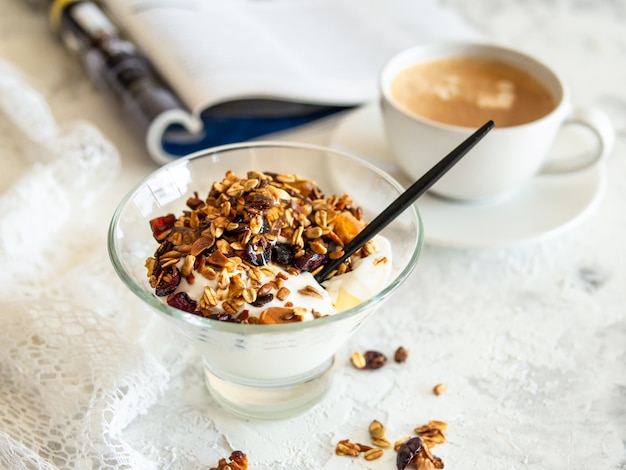 Café da manhã saudável. Granola, muesli com sementes de abóbora, mel, iogurte em uma tigela de vidro
