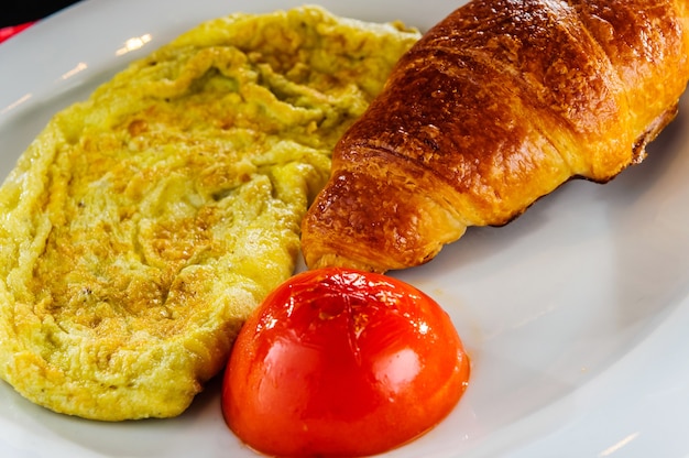 Café da manhã saudável, omelete e croissant.