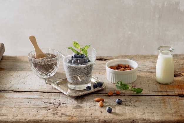 Café da manhã saudável ou lanche da manhã com pudim de sementes de chia e frutas no fundo rústico de madeira, comida vegetariana, dieta e conceito de saúde