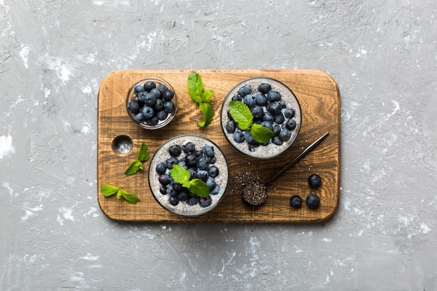 Café da manhã saudável ou manhã com sementes de chia pudim de baunilha e bagas de mirtilo no fundo da mesa dieta alimentar vegetariana e conceito de saúde pudim de chia com leite de coco e mirtilo