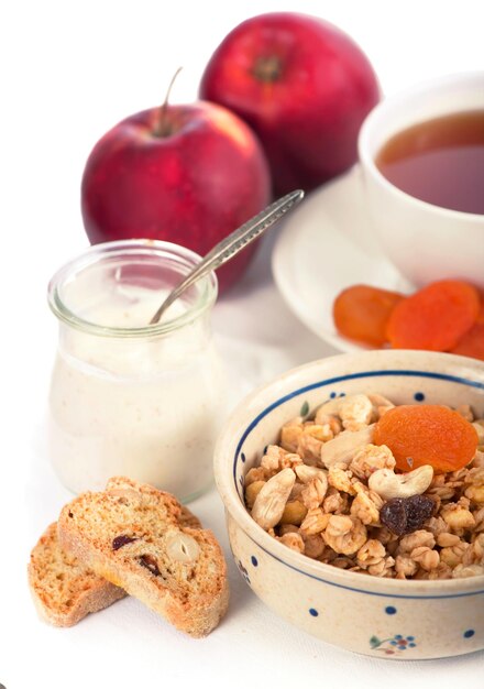 Café da manhã saudável. Taça de iogurte com granola, damascos secos e maçãs