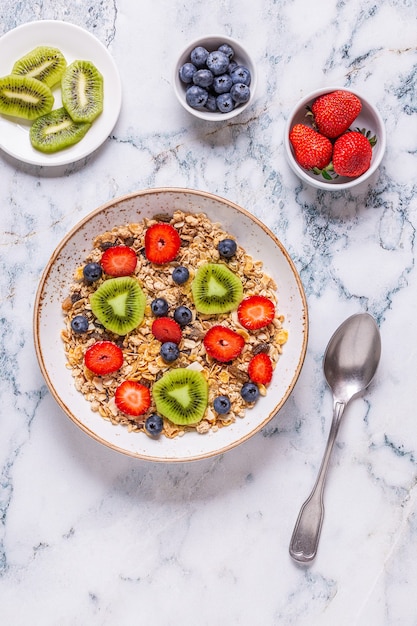 Café da manhã saudável, tigela com granola de aveia e frutas, vista superior.