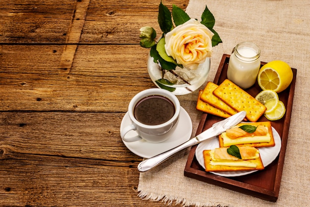 Café da manhã saudável. Xícara de café (chá preto), leite, bolachas com manteiga e salmão