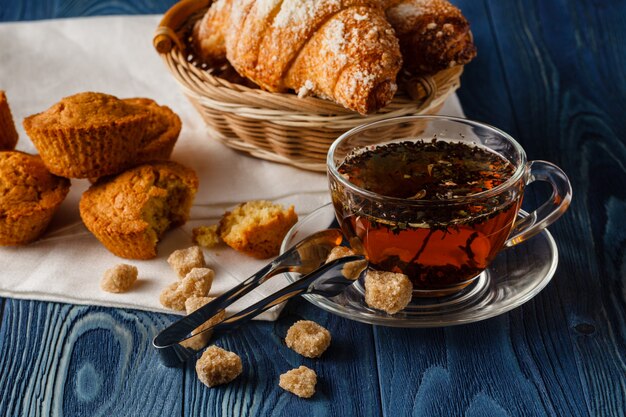 Café da manhã tradicional com chá preto e croissants, fundo de madeira vintage, foco seletivo