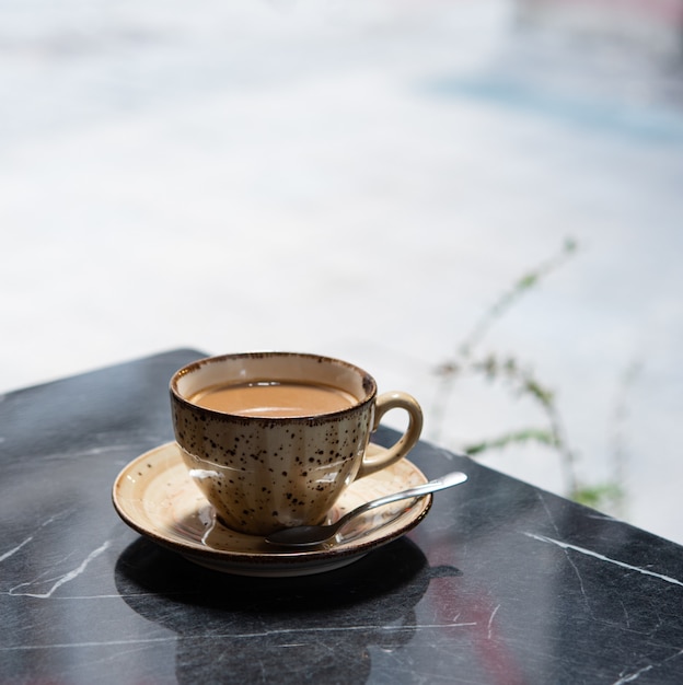 Café da manhã. uma xícara de café perfumado fica em uma mesa de mármore preto em um café de verão em istambul