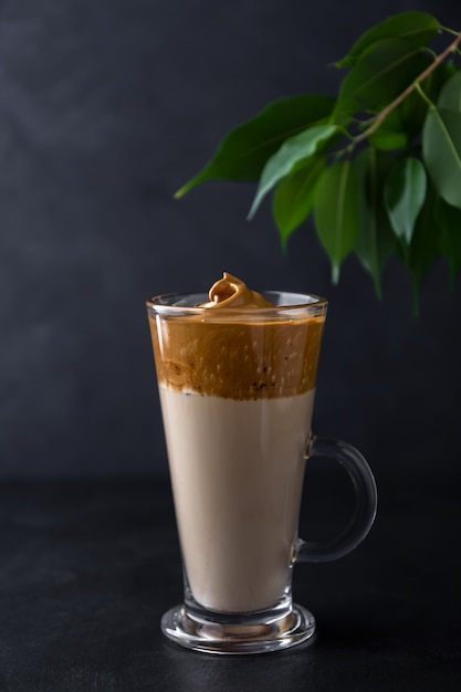 Café Dalgona em um copo de vidro em um espaço preto