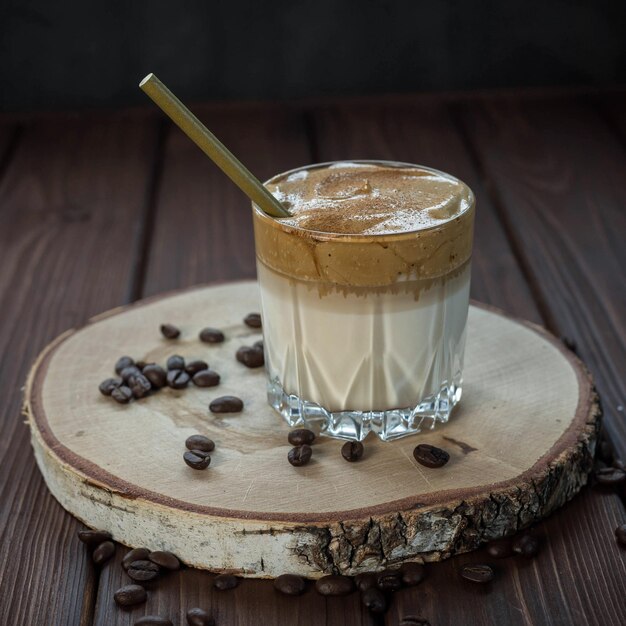 Café dalgona em uma mesa de madeira e grãos de café torrados bebida coreana com café