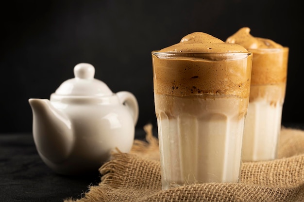 Café Dalgona helado, vaso con leche y crema de café.