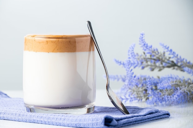 Café Dalgona. Un vaso de bebida de leche de moda en una servilleta azul.