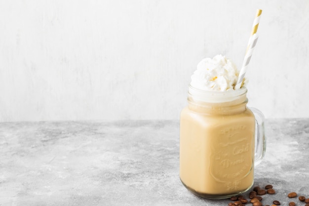 Café de gelo com leite e creme em um fundo cinzento. copie o espaço. fundo de alimentos