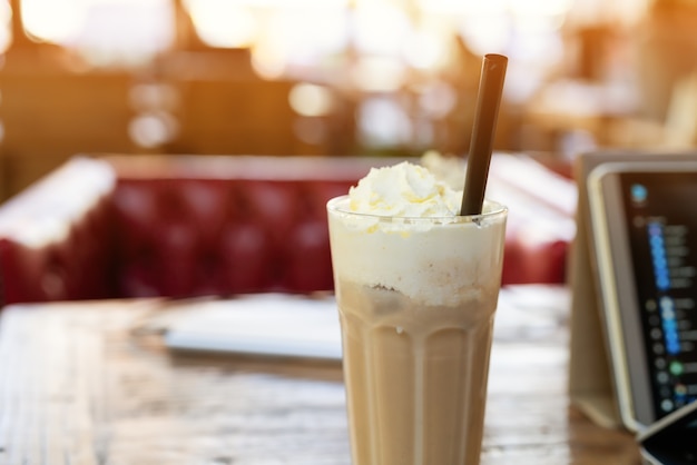 Café de mocha de gelo na mesa de madeira com almofada de computador inteligente