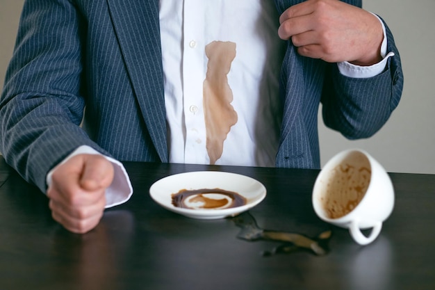 Un café derramado de cerca en una camisa blanca