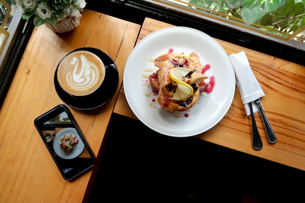 Café para el desayuno con croissant de limonada