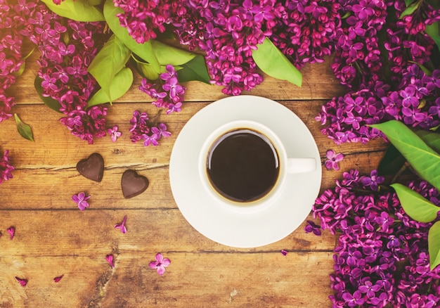 Café para el desayuno y flores lilas. Enfoque selectivo