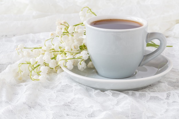 Café e buquê de flores - lírios do vale