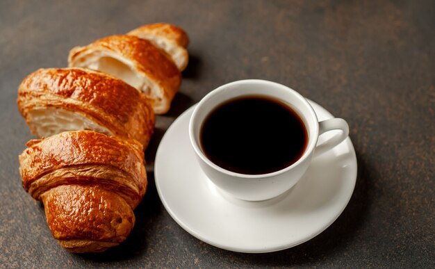 Café e croissant em um fundo de pedra. café da manhã saboroso