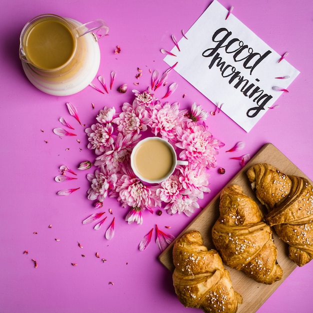 café e croissant em um fundo rosa