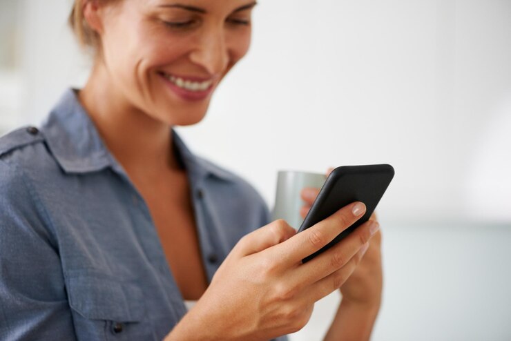 Foto café e uma conexão wi-fi é tudo que você precisa. foto de uma mulher segurando seu celular enquanto tomava café em casa.