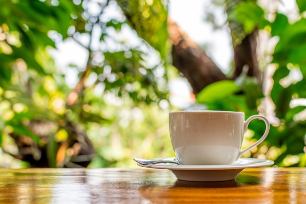 Café em copo branco na mesa de madeira na cafeteria