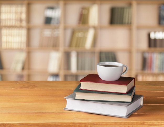 Foto café em copo com livros em fundo bokeh