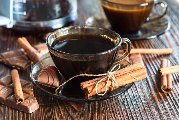 Café em copo de vidro e canela na mesa