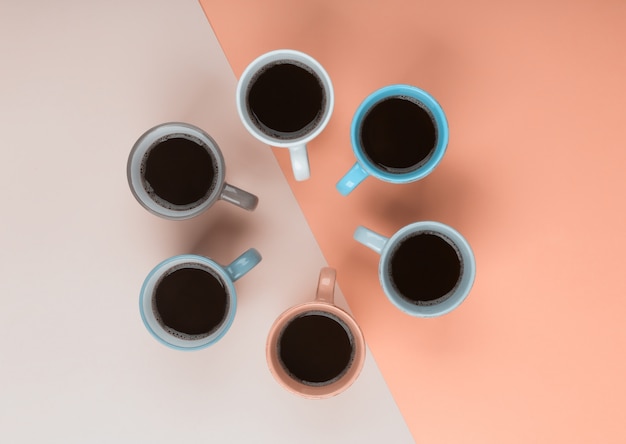 Café em copos diferentes no fundo coral. Flatlay, conceito de dia alegre