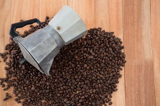 Foto café em grão com cafeteira metálica