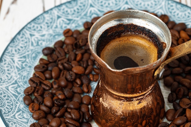 Café em turco de cobre com grãos de café