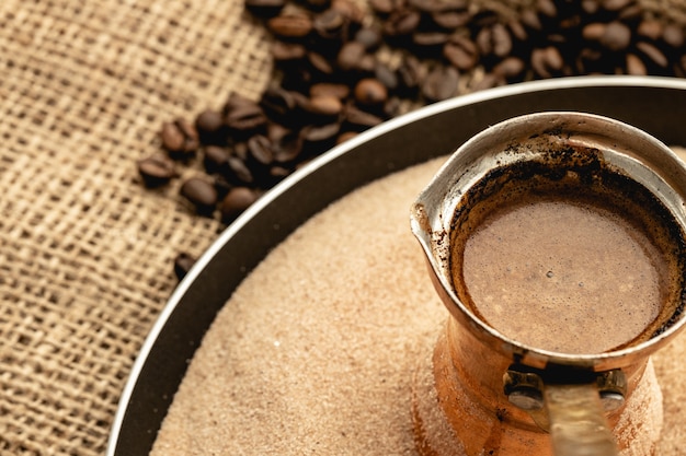 Café em turco de cobre cozido na areia quente