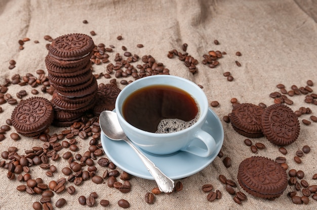 Café em uma xícara azul. biscoitos de chocolate próximos.