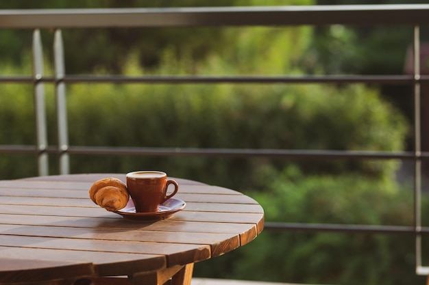 Café em uma xícara com croissant no café da manhã Café expresso com croissant no café da manhã