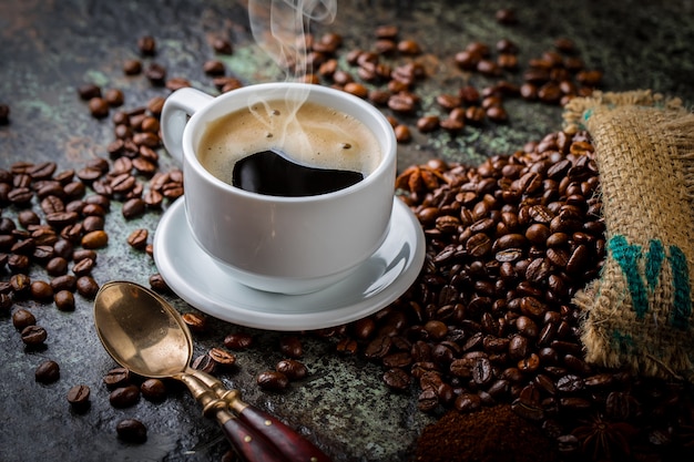 Café em uma xícara e Pires com grãos de café